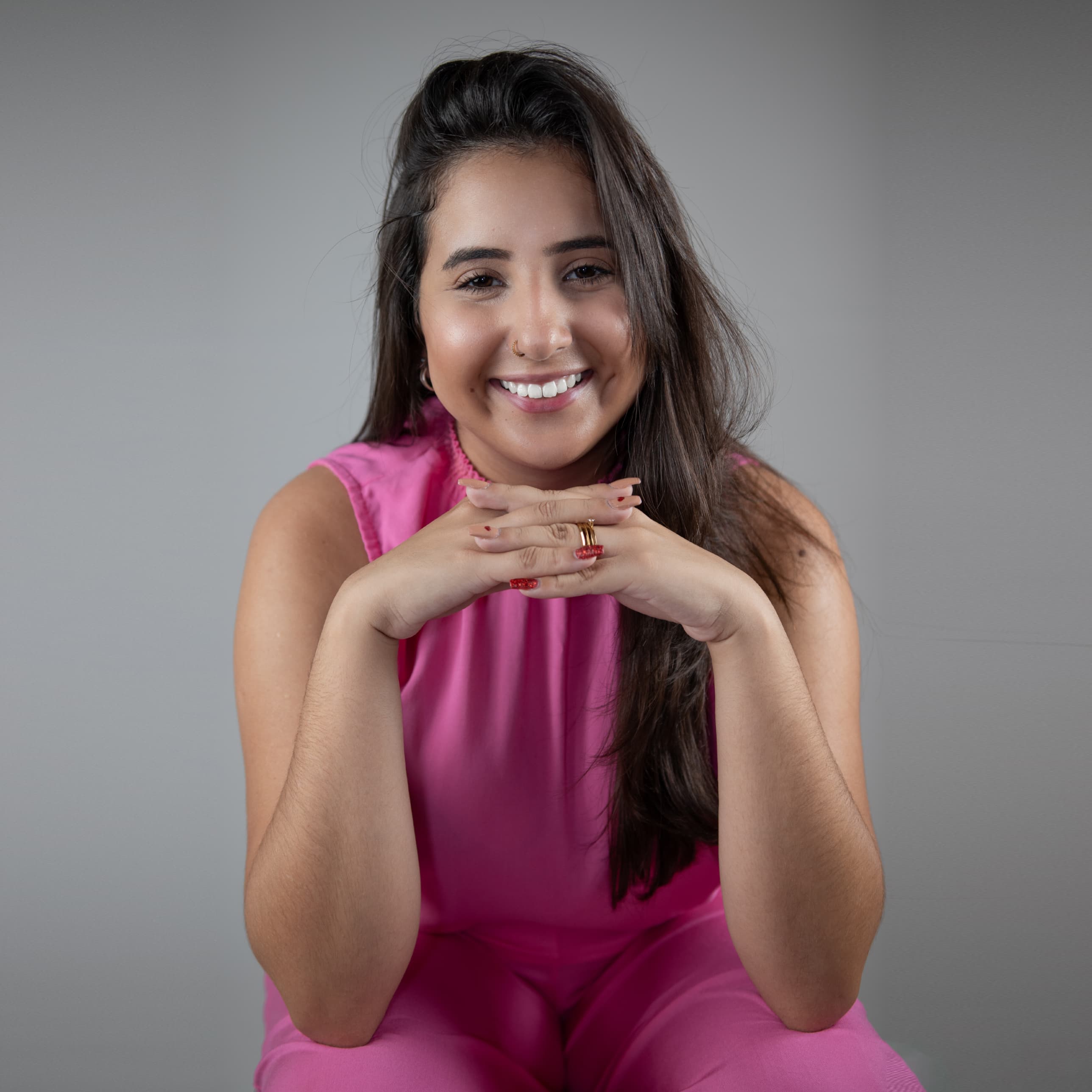 Any Medola, smiling with a teal top, arms crossed